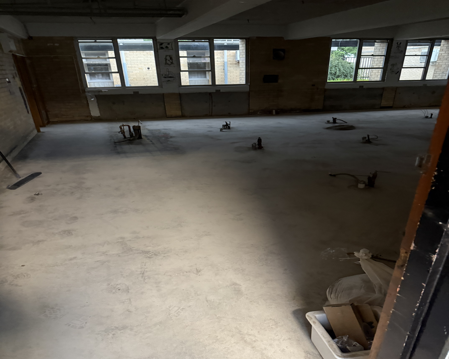 Mechanically prepared concrete beside classroom windows after follow-up 30-grit grinding