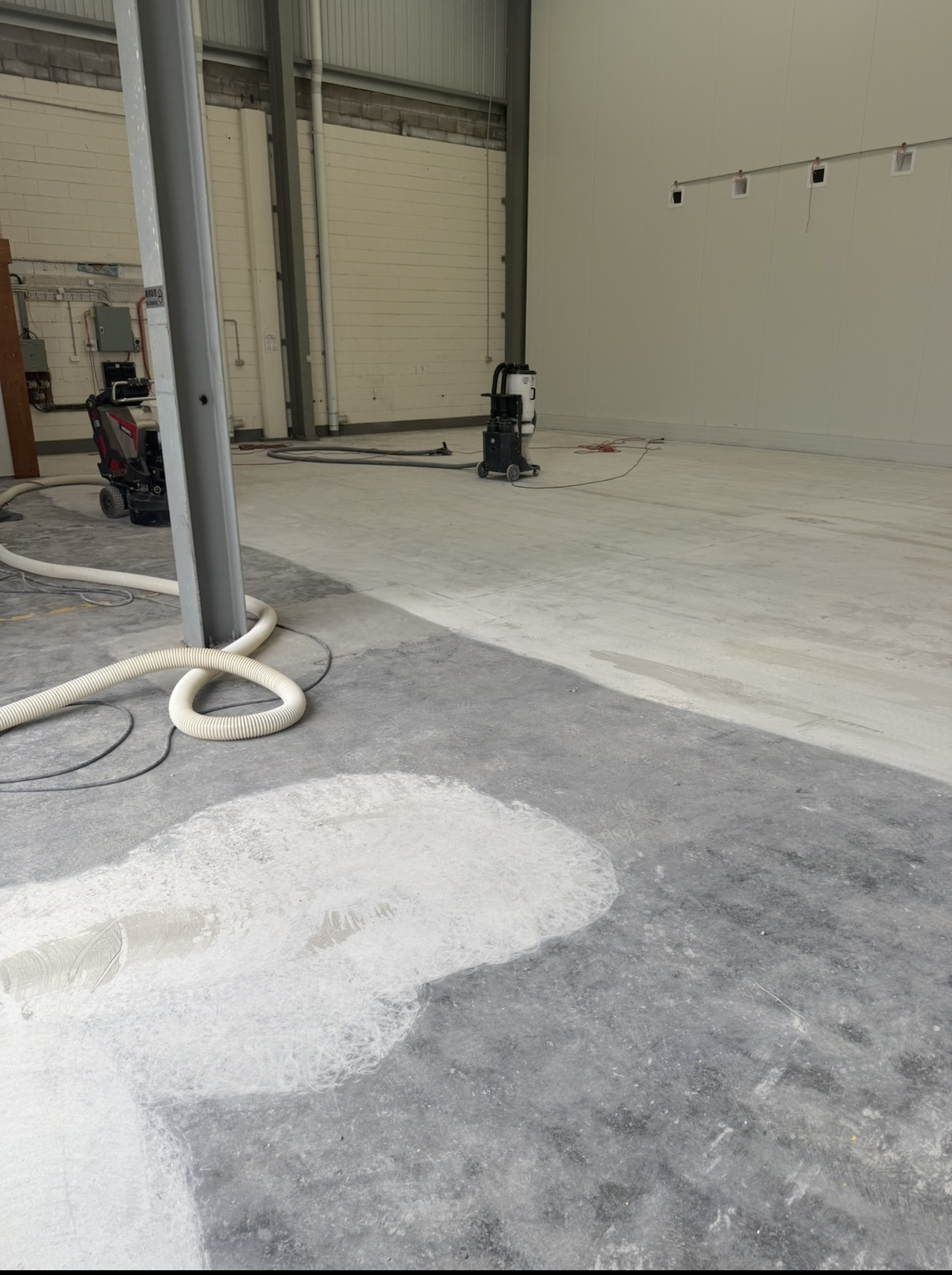 Commercial grinders and industrial dust extractors preparing the food warehouse concrete floor