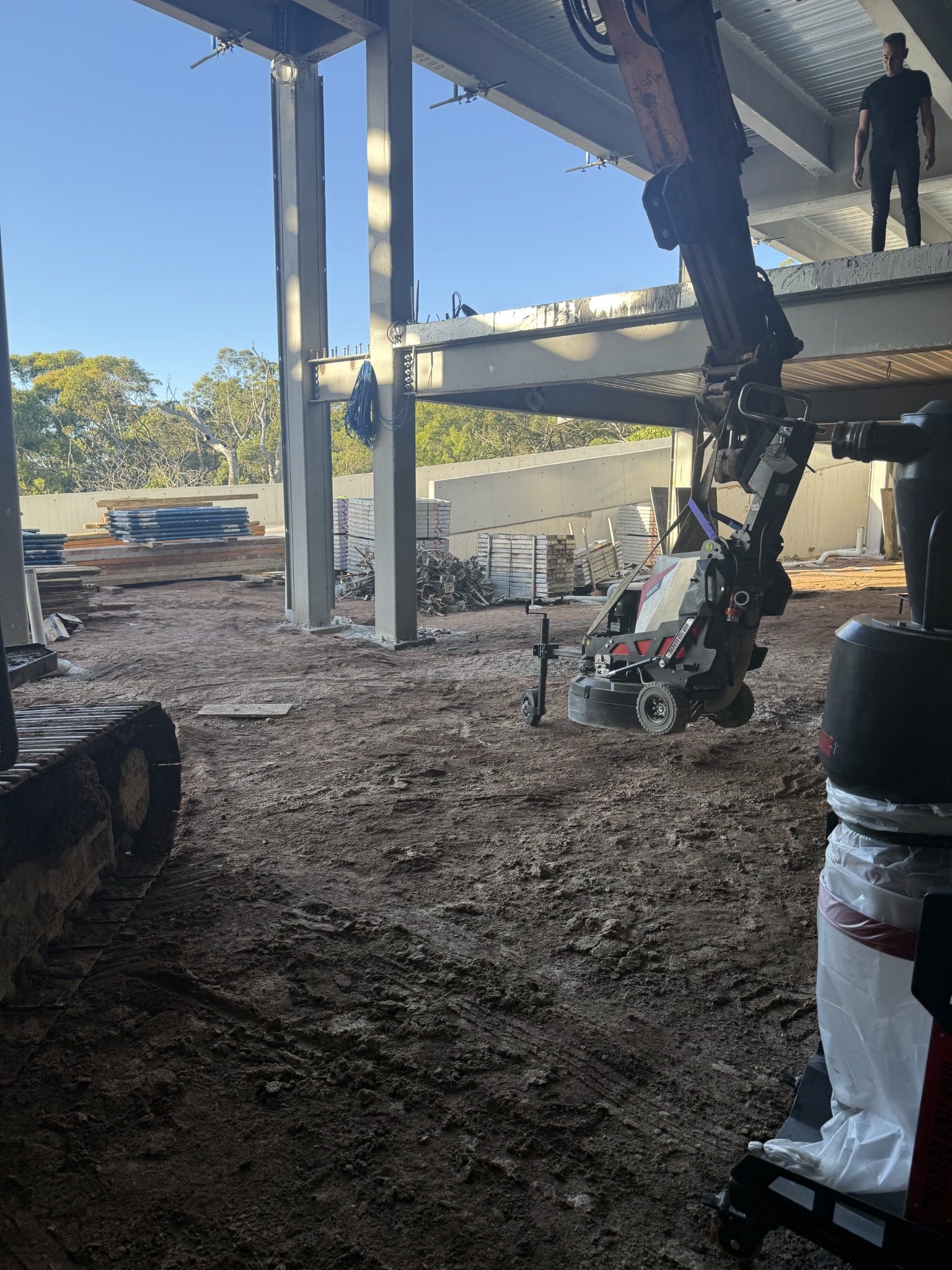 Commercial grinding equipment being lifted onto the elevated concrete slab