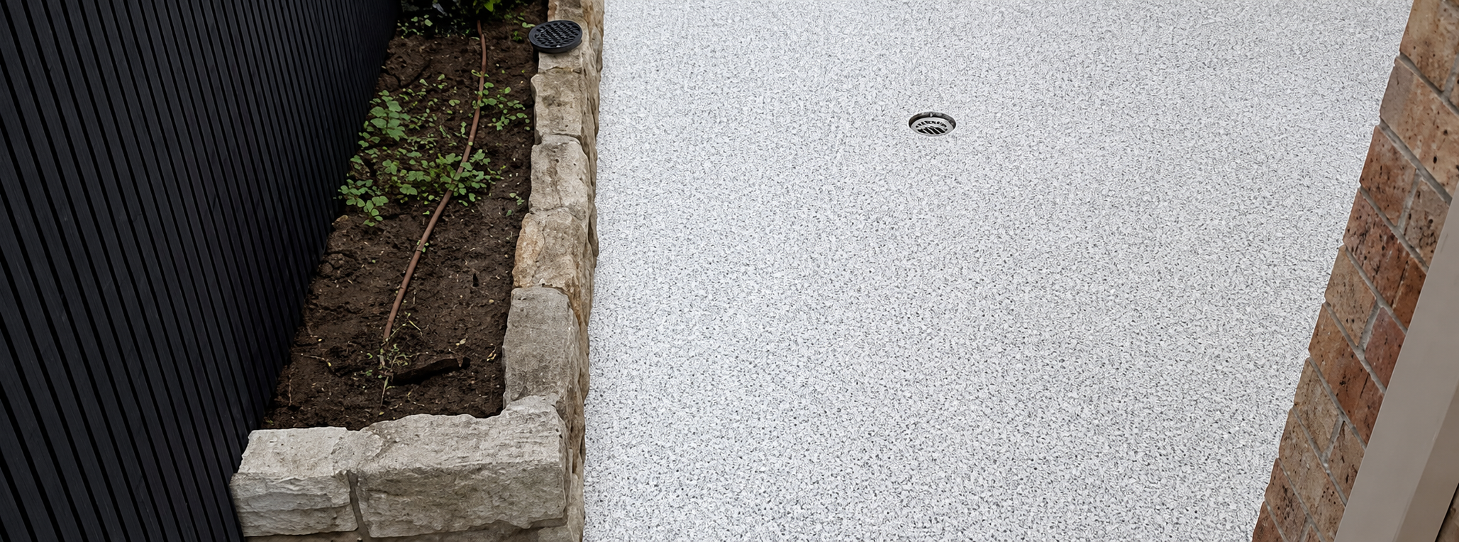 Finished outdoor epoxy flake floor beside the boundary fence and garden bed
