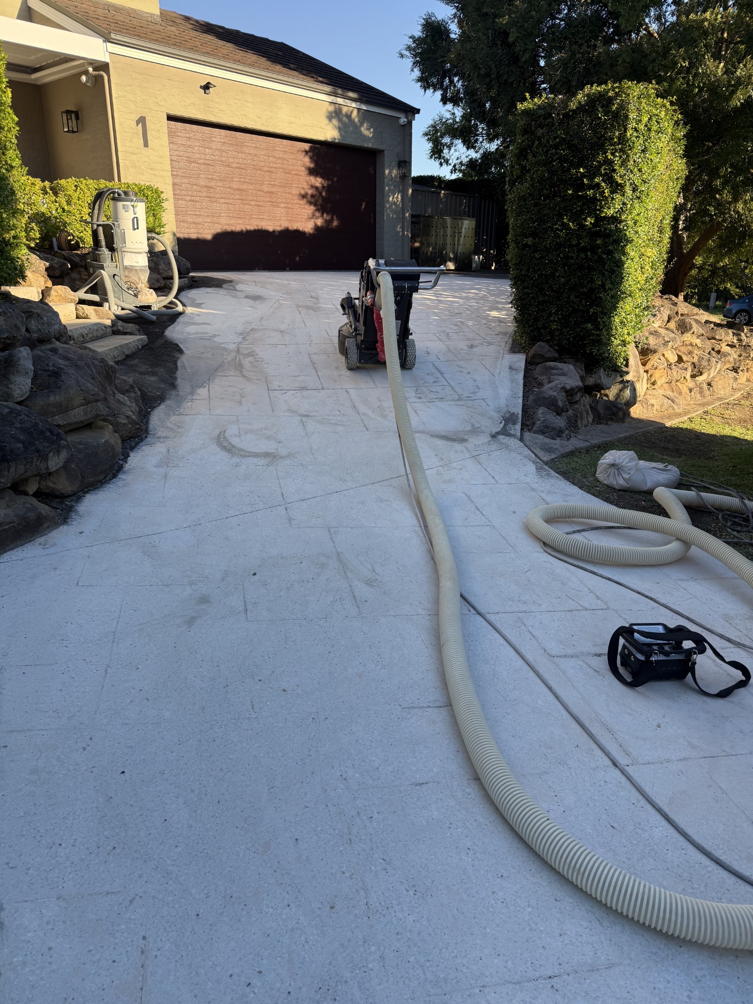Driveway after repeated grinding passes removed the stamped pattern and left a coarse concrete profile