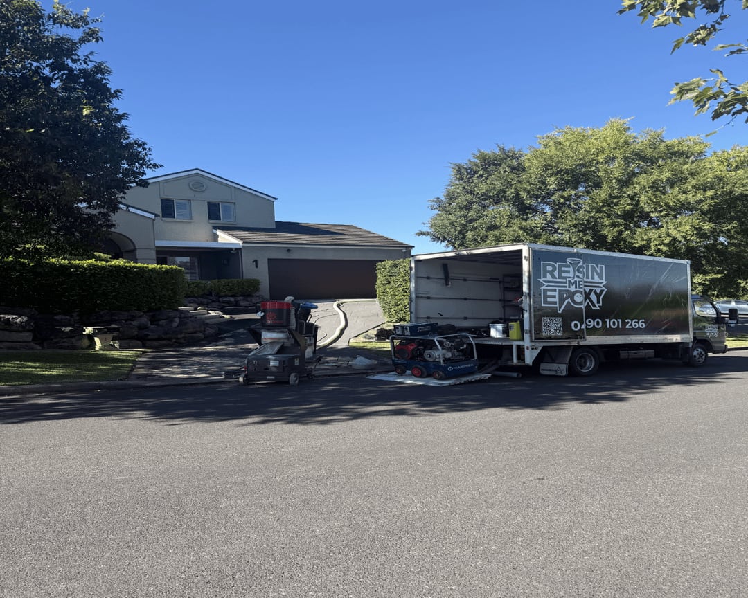 Resin Me Epoxy truck and concrete-grinding equipment outside a residential driveway