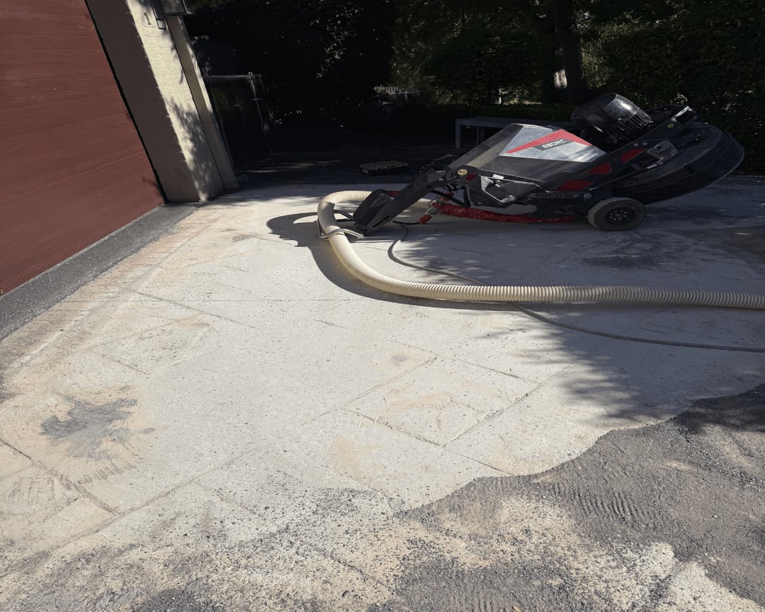Ground residential driveway beside the garage with a dust-extraction hose connected