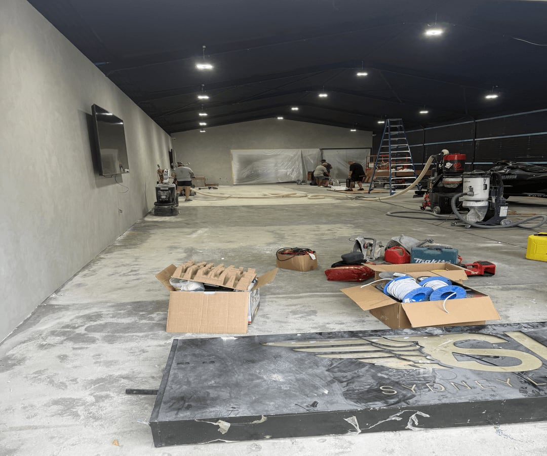 Concrete grinders and connected dust extraction operating across the 300 m² Parramatta showroom