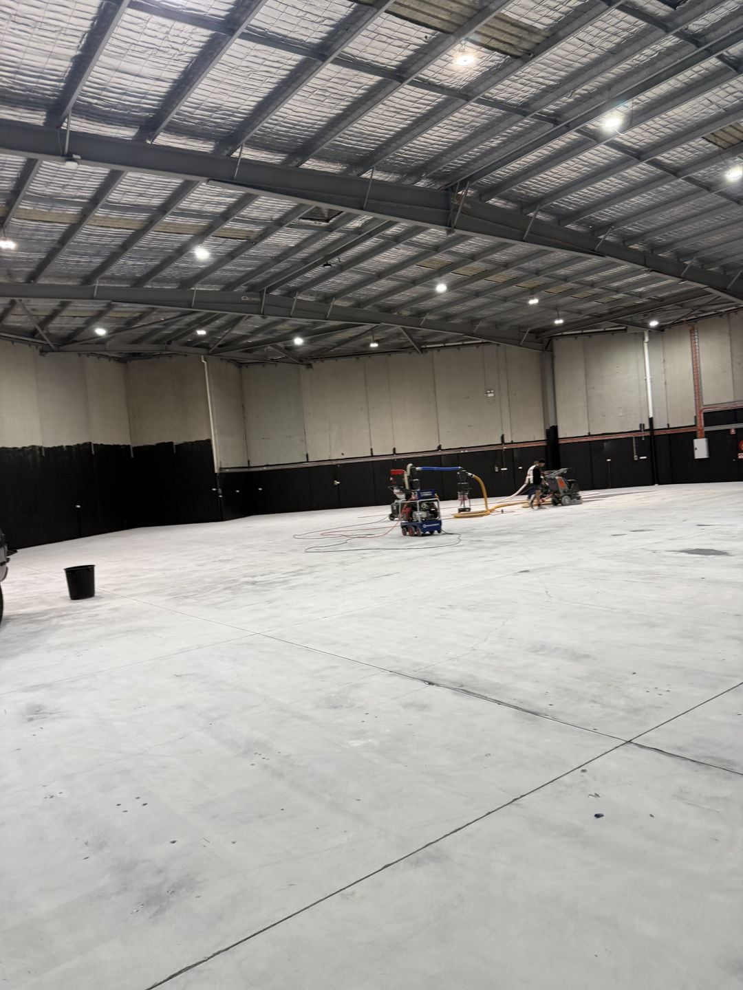 Two commercial floor grinders preparing the open Campbelltown warehouse slab