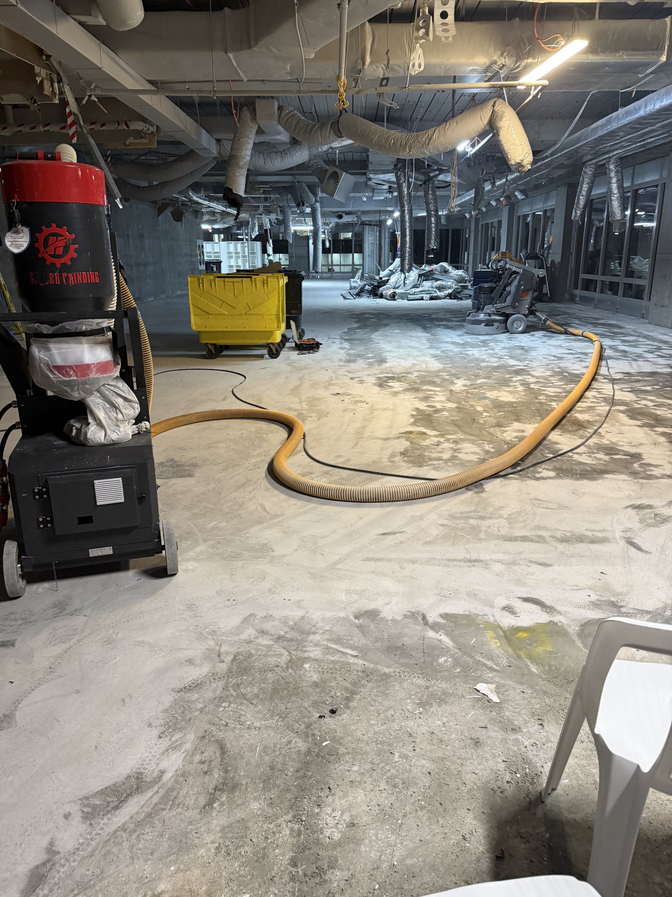 Commercial grinder and industrial dust extractor preparing a concrete floor inside a Sydney CBD tenancy