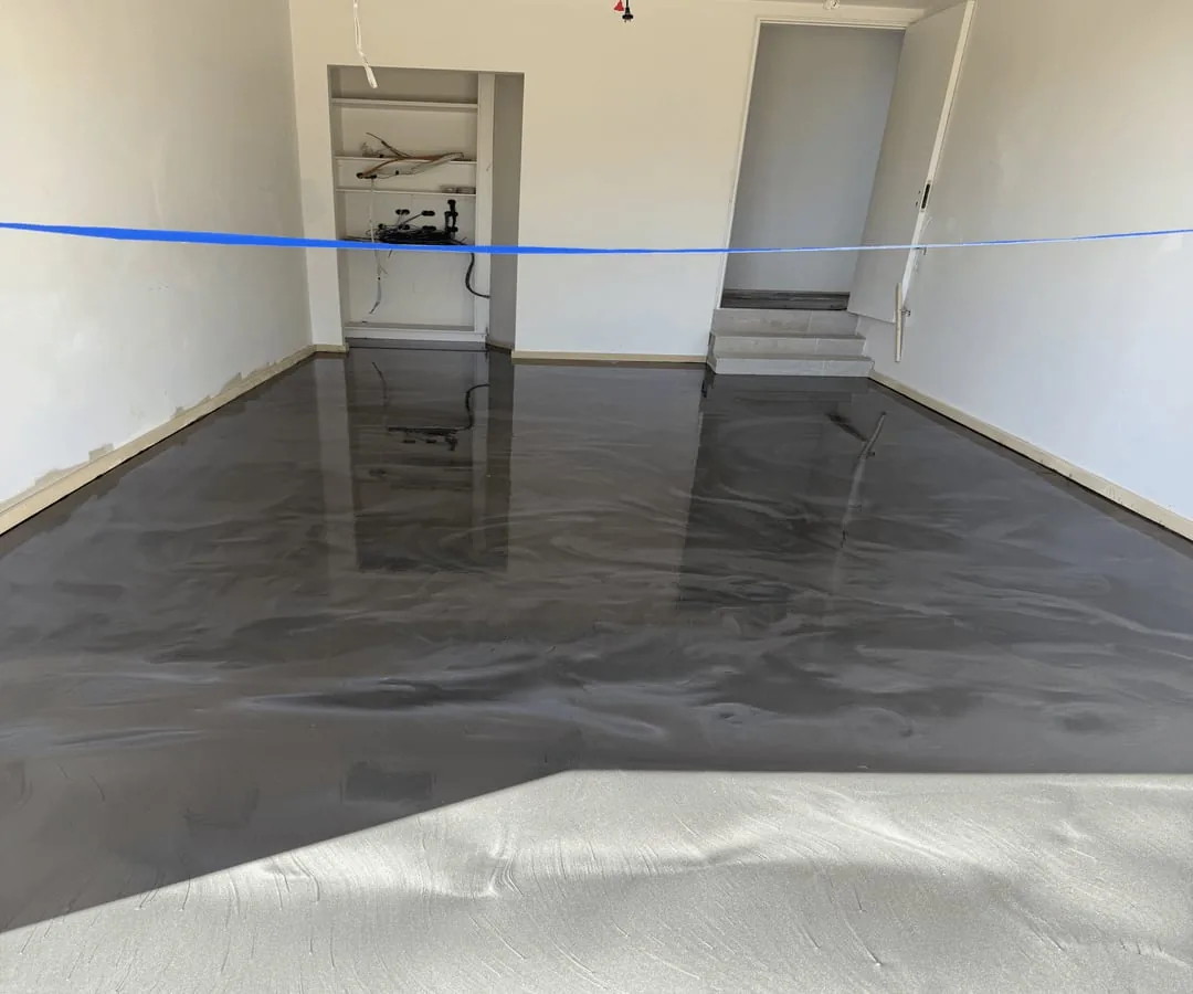 Finished gunmetal metallic epoxy floor in Lakemba, with grey marbling reflected beneath rear steps and shelving.