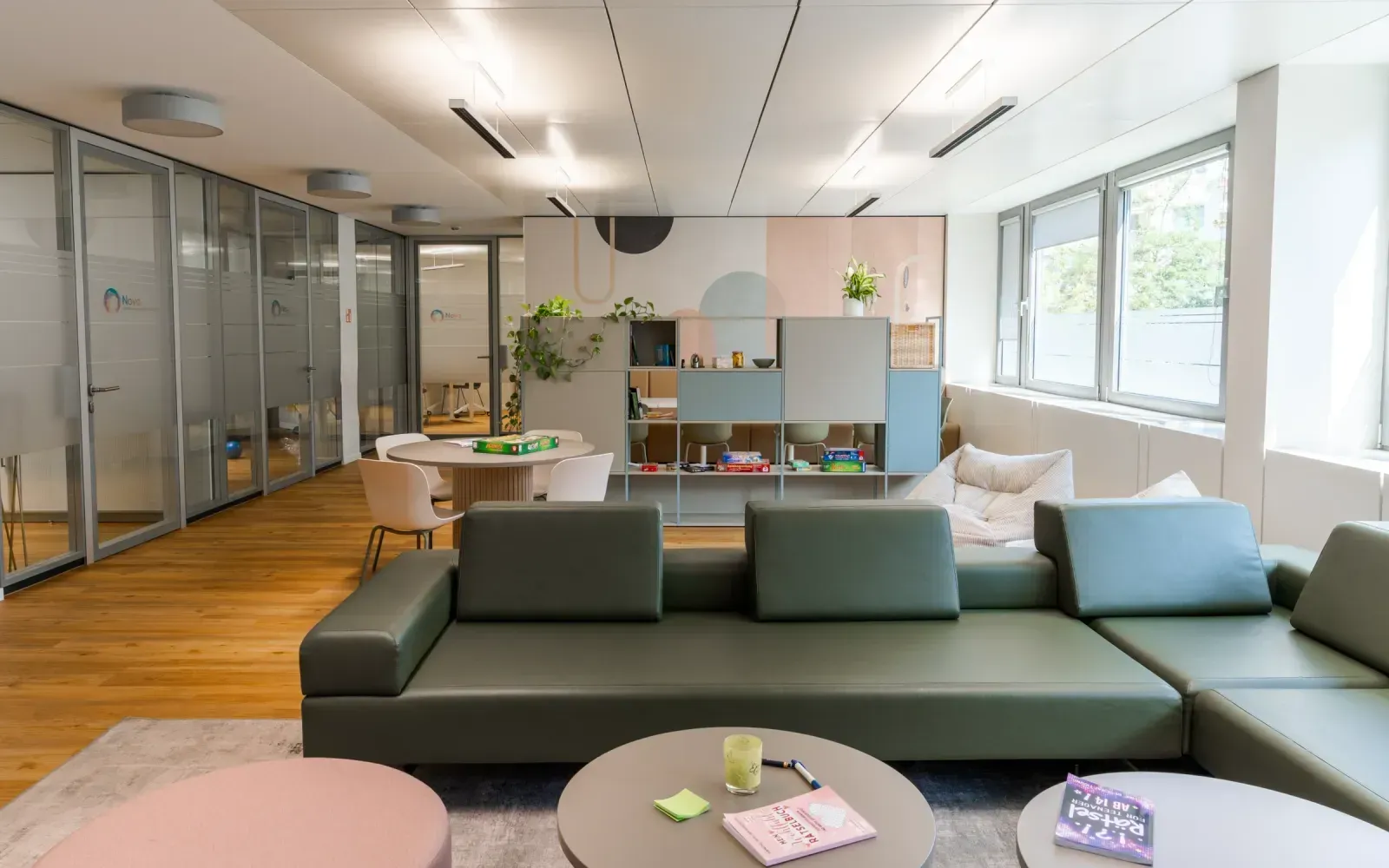 Loungebereich der Tagesklinik mit großem, grünen Sofa und Blick in den Raum.