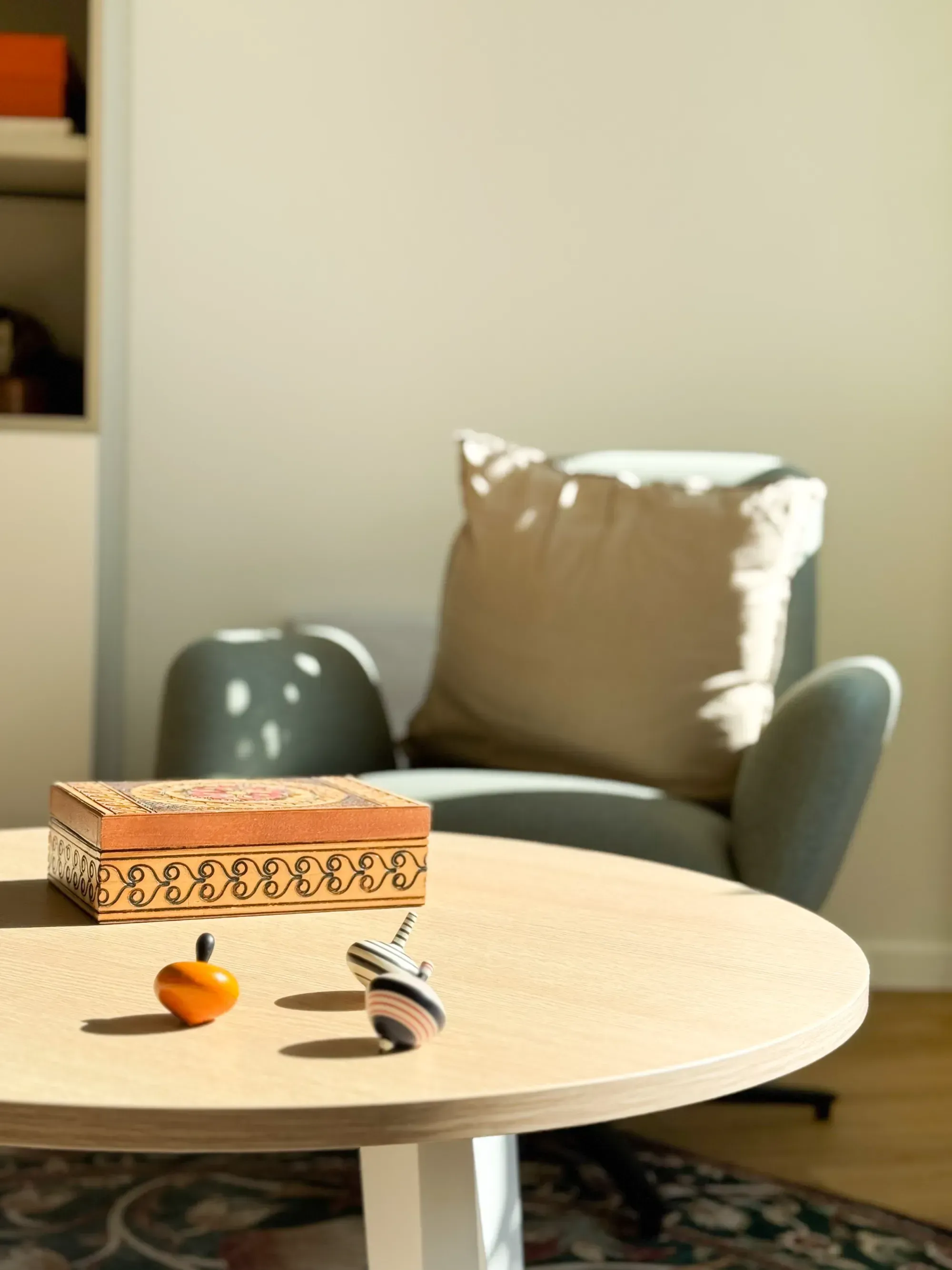 Nahaufnahme eines Holztisches mit einer Schatulle und zwei Spielzeugkreiseln.