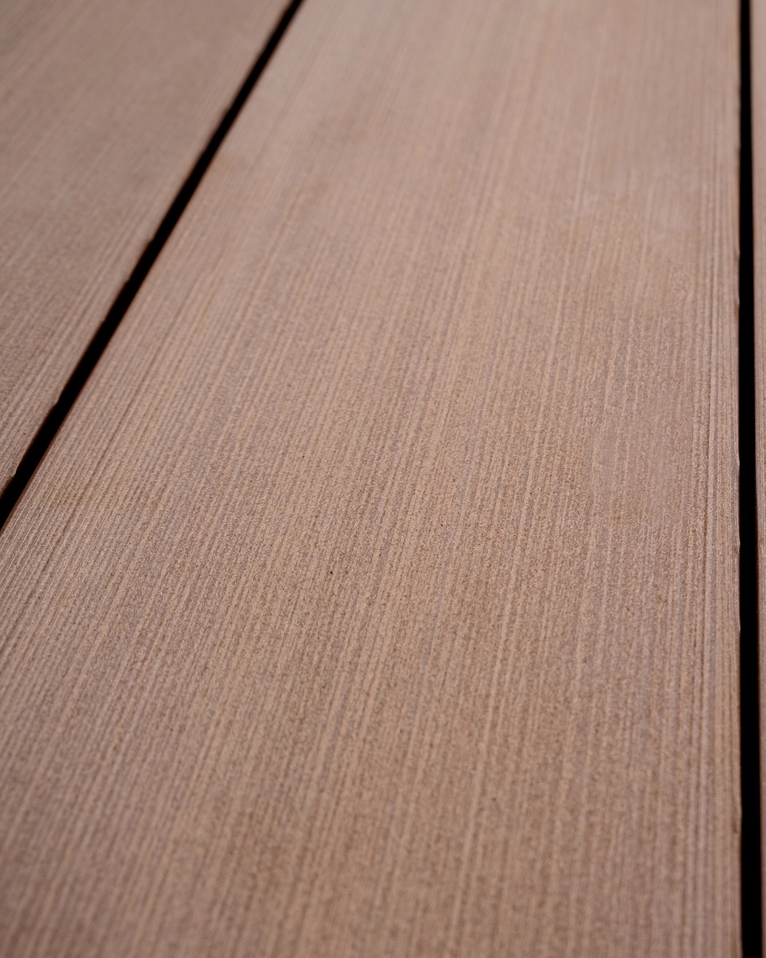 Close view of a warm-toned Tarimatec board surface and finished edge
