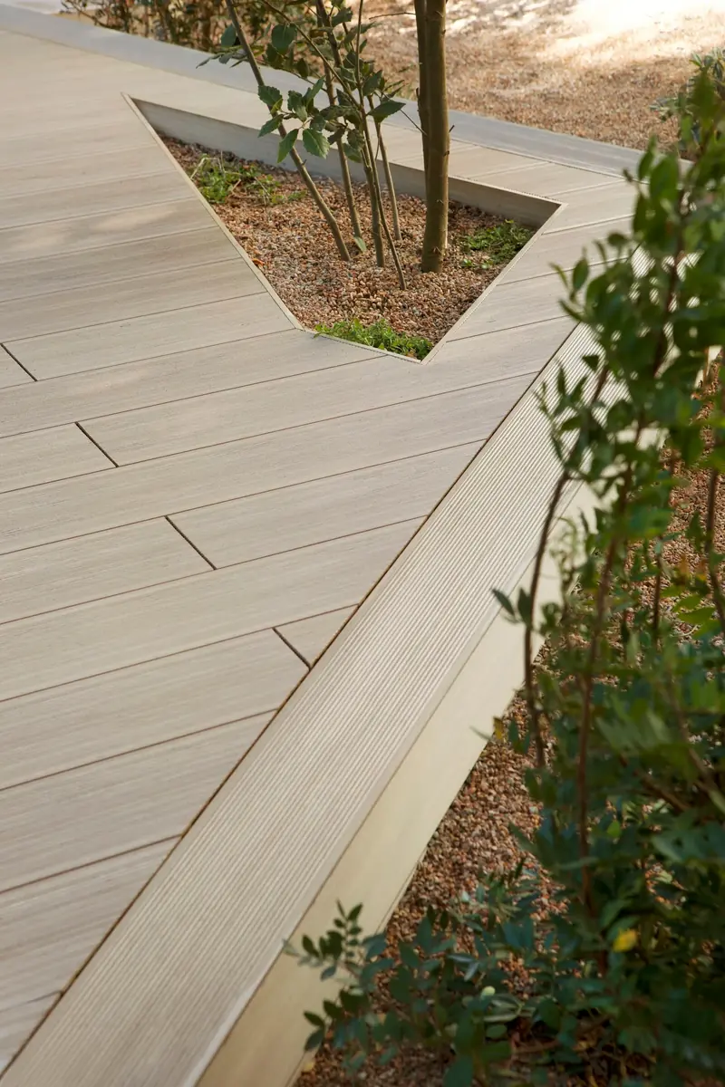 Wood-look Tarimatec composite decking beside a garden