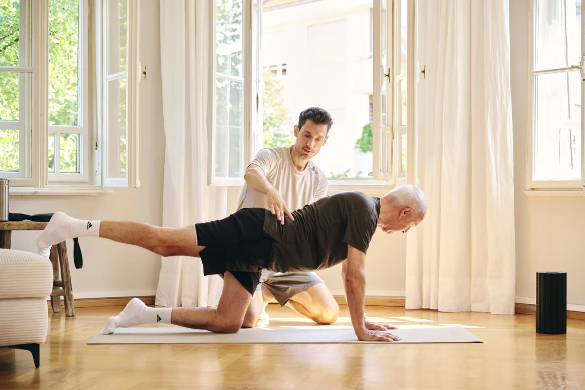 Klient trainiert unter Anleitung von Lars Traxel eine Übung zur Rückenmobilität im Präventionstraining.