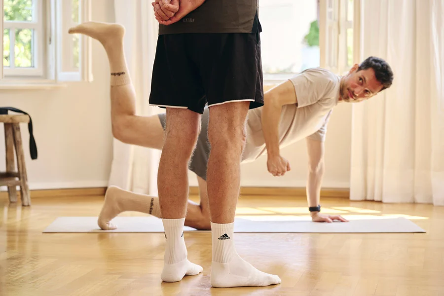 Lars Traxel leitet Klienten bei einer Bodenübung zur Rumpfstabilität an.