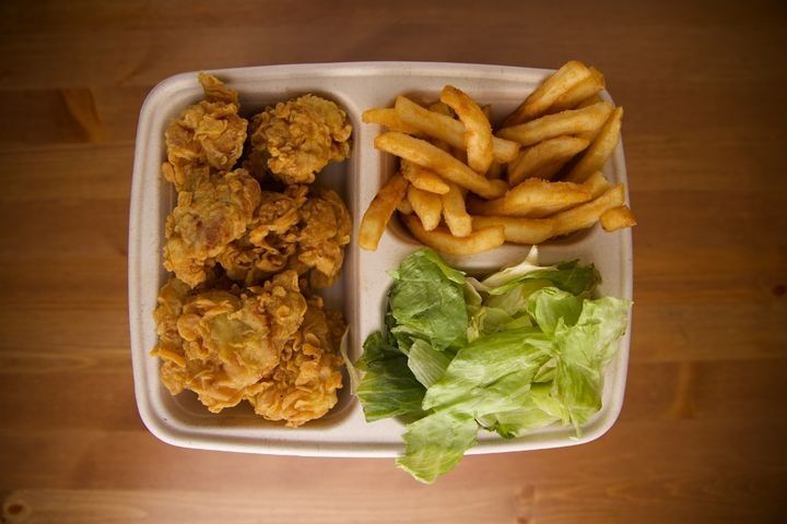 A serving of boneless fried chicken with Cajun fries, side salad, and dipping sauce.