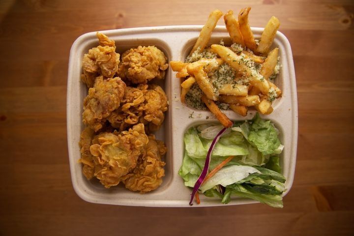 A serving of boneless fried chicken with Parmesan truffle fries, side salad, and dipping sauce.