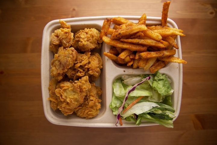 A serving of boneless fried chicken with Parmesan truffle fries, side salad, and dipping sauce.