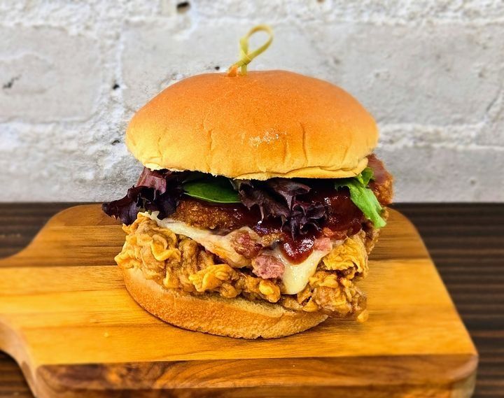 A BBQ fried chicken sandwich with mozzarella, bacon bits, and a hash brown.