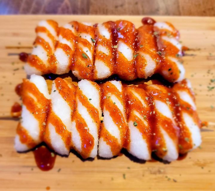 Two skewers of crispy-fried rice cakes in a sweet and spicy glaze.