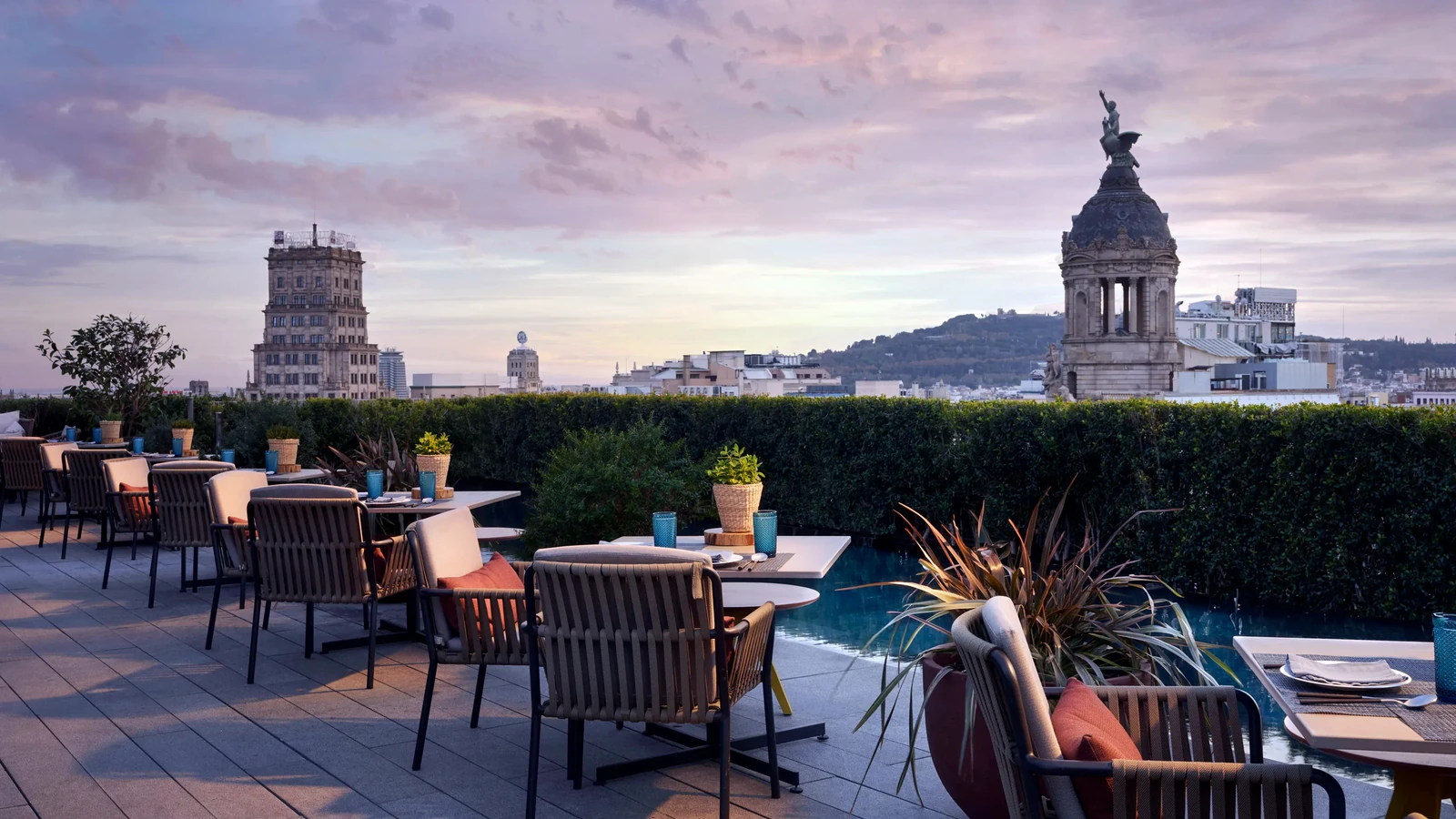 Dining tables on the Terrat rooftop at Mandarin Oriental Barcelona with the Barcelona skyline behind