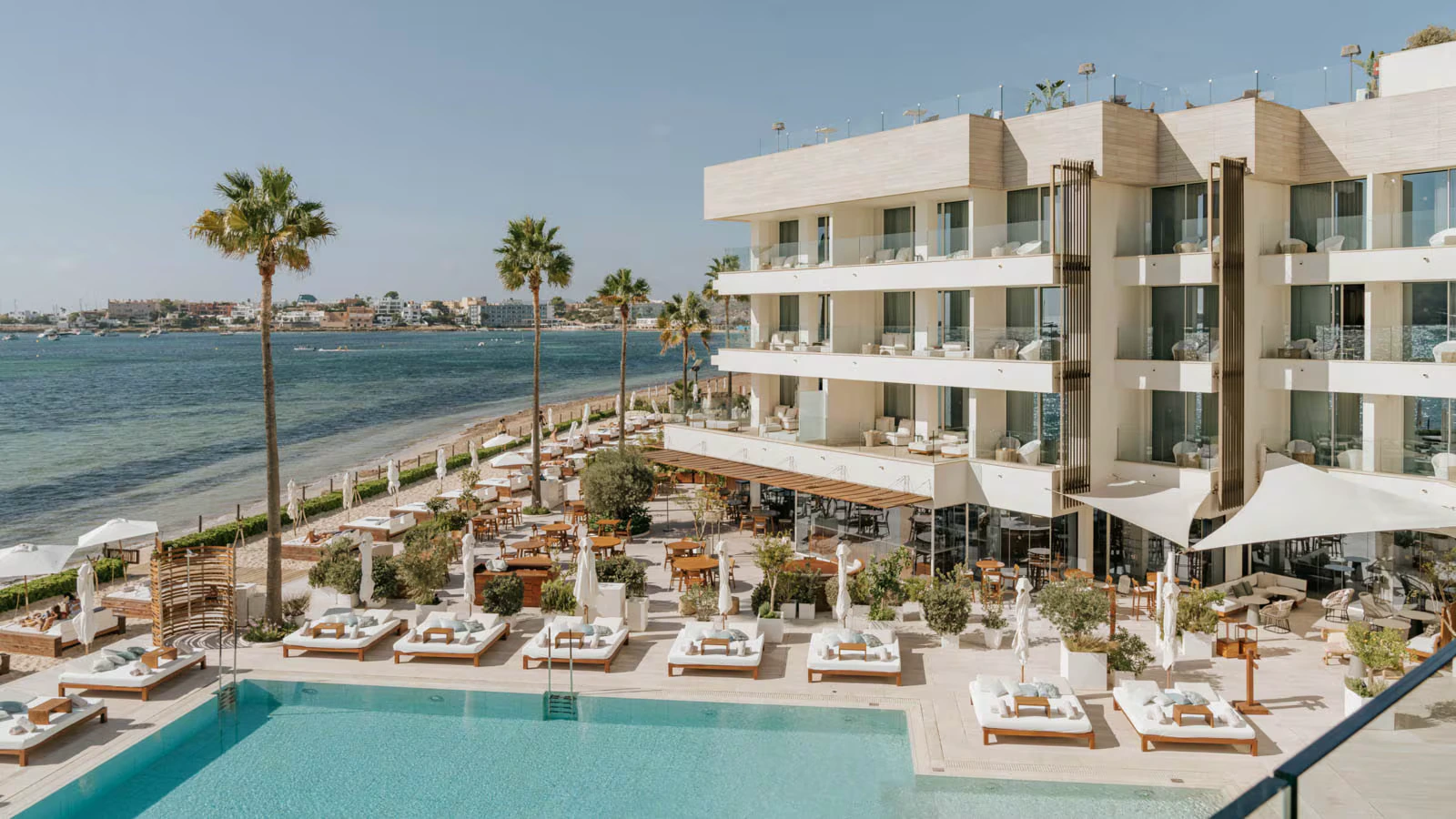 Nobu Hotel Ibiza Bay seen from the shore, the pool terrace running along the coast
