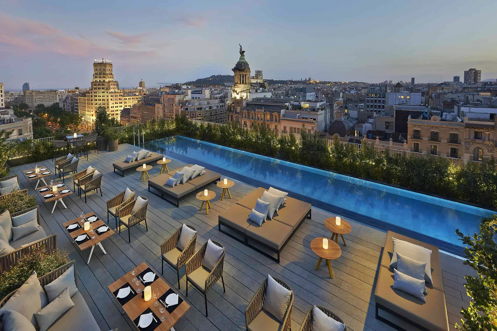 The Terrat rooftop terrace and pool at Mandarin Oriental Barcelona at dusk, over the Eixample rooftops
