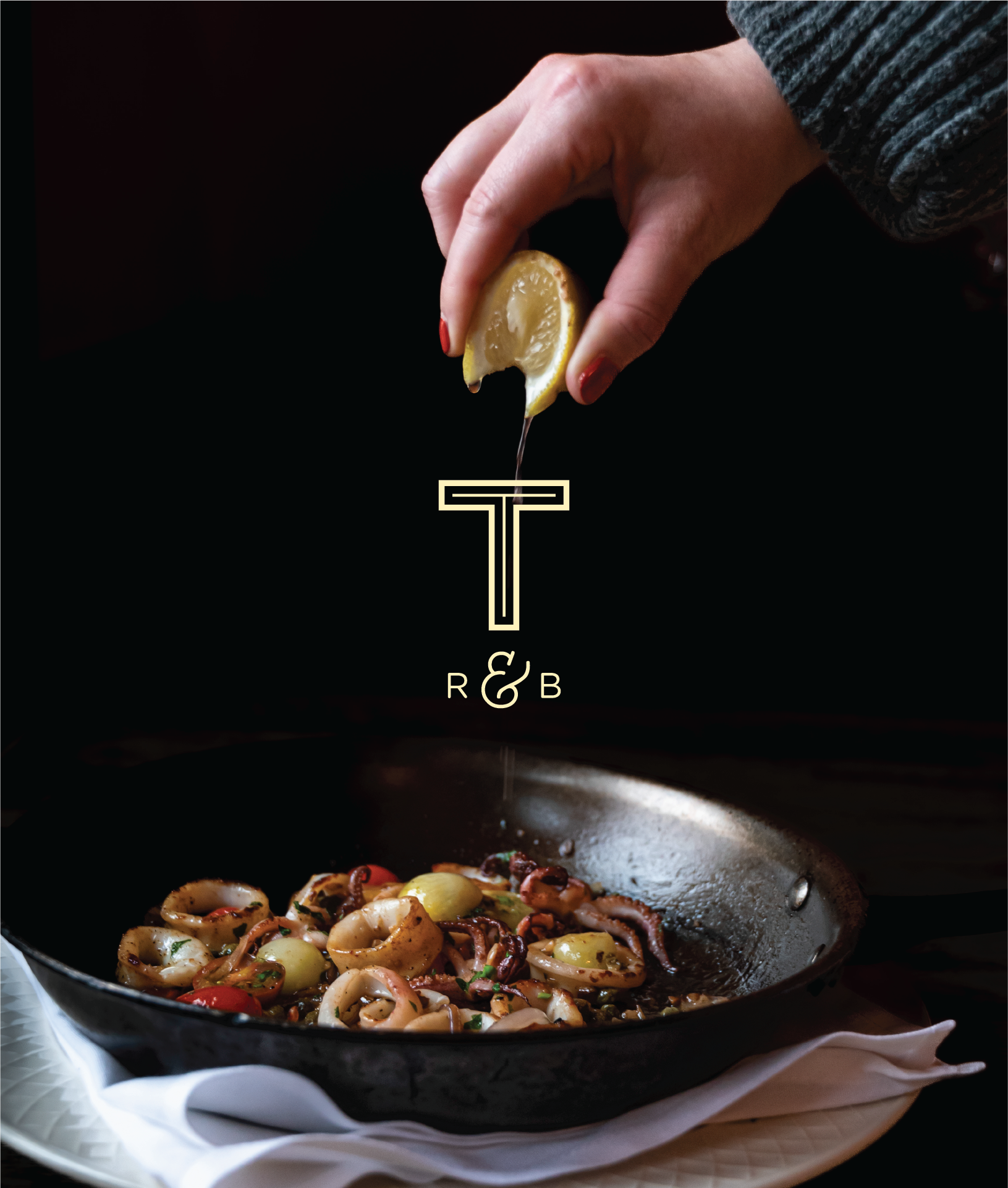 Moody, high-contrast food photography featuring a pan of calamari being seasoned with fresh lemon. The restaurant's "T & B" logo is centered in the image.