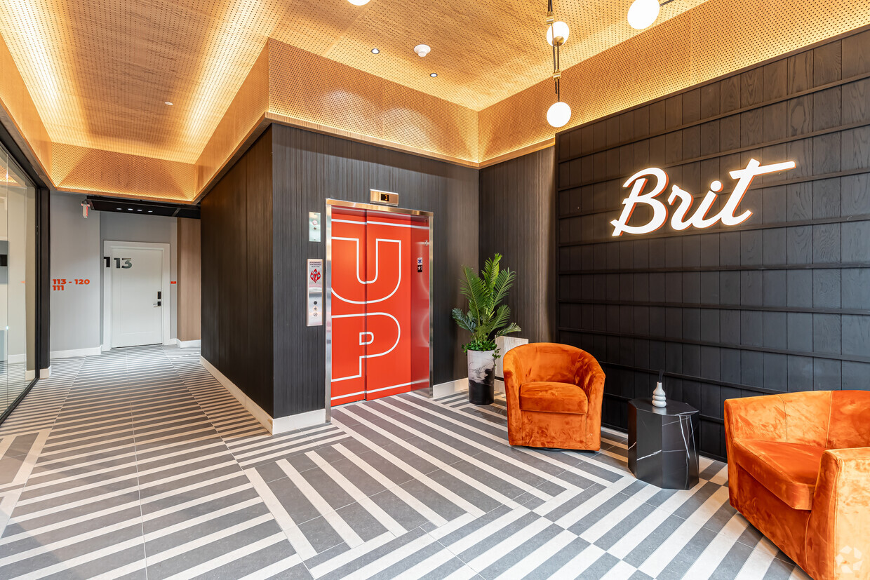 Image of the Brit's interior, emphasizing the eclectic design with its mix of textures, colors, and materials, including a statement elevator, plush velvet seating, and a geometric floor pattern, creating a visually engaging and stylish environment.