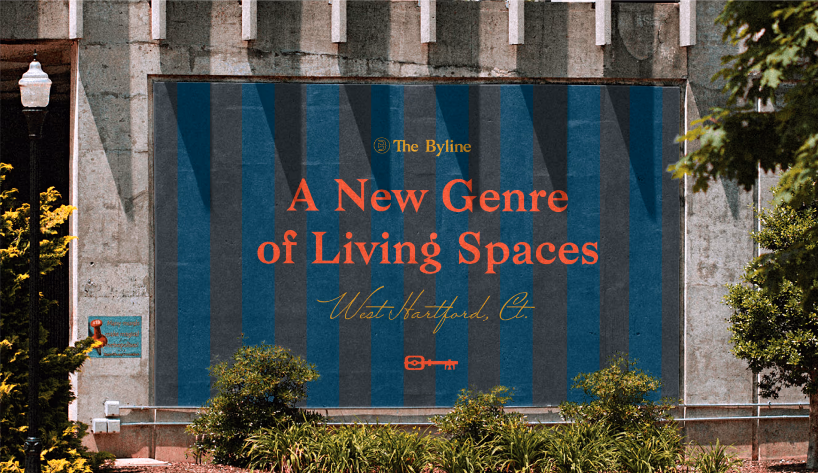 Image of a building-mounted banner showcasing "The Byline" branding and marketing message, highlighting the use of typography, color palette, and a symbolic key graphic to attract potential residents.