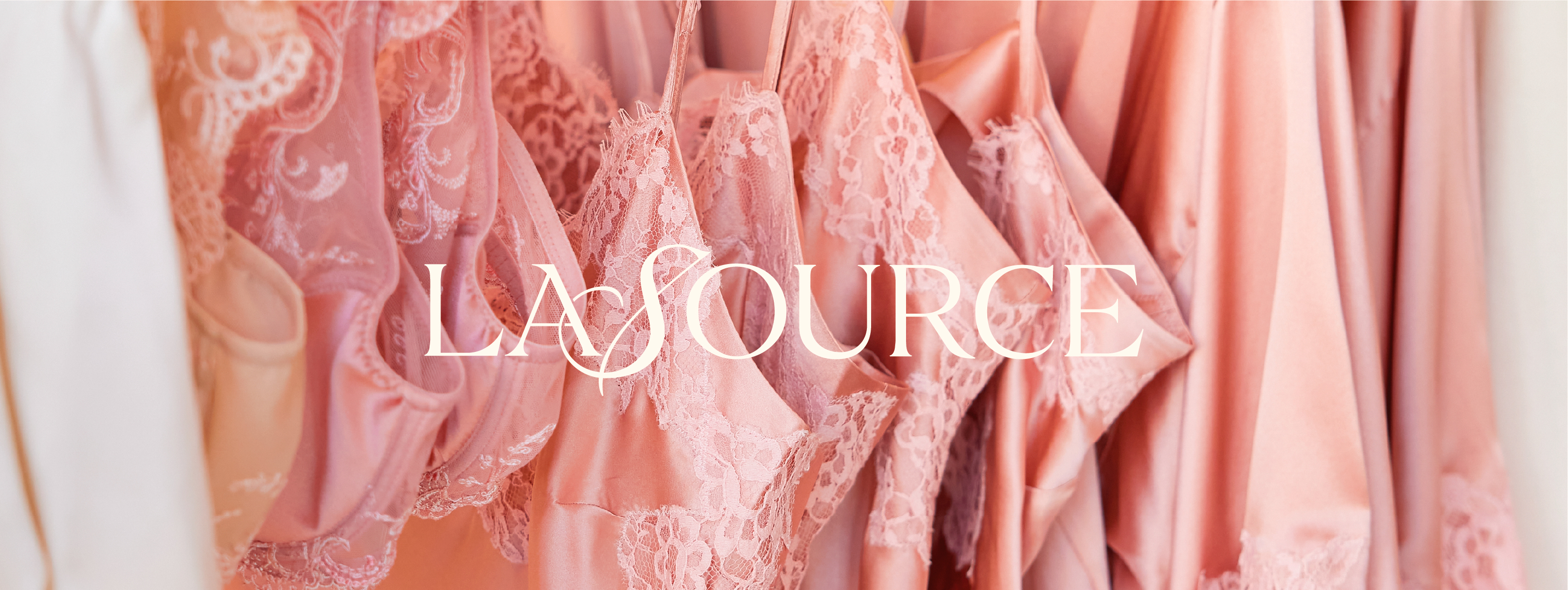 Stylized image showcasing feminine apparel with a focus on texture and branding. Soft, pink fabrics with lace details are partially visible, with the "LASOURCE" logo prominently displayed.