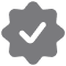 Gray verified badge or checkmark icon with a stylized design