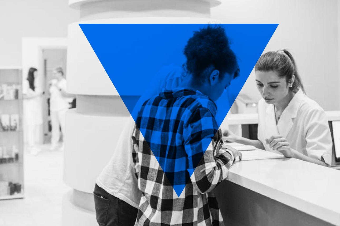 Patient in plaid shirt consulting with medical professional at reception