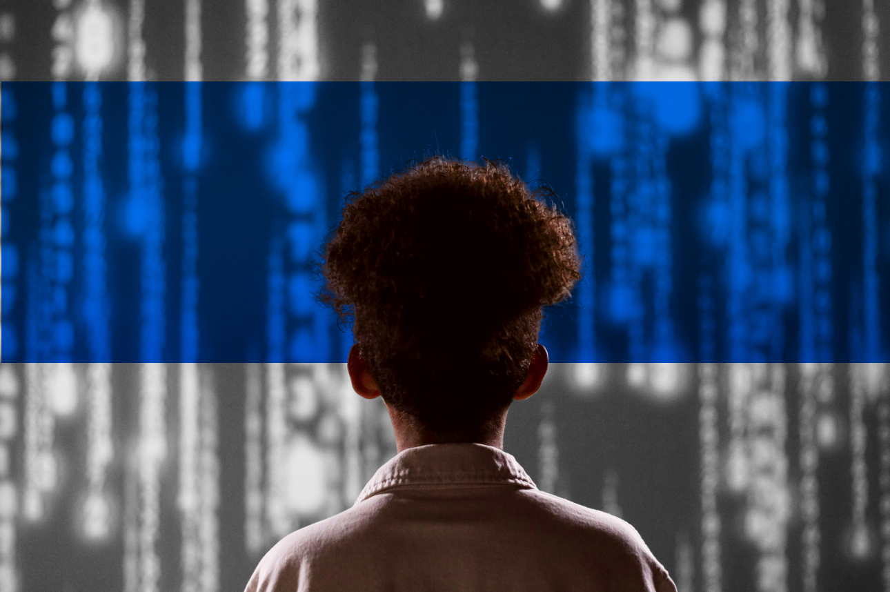 Back of person with curly hair looking at blurred blue digital background