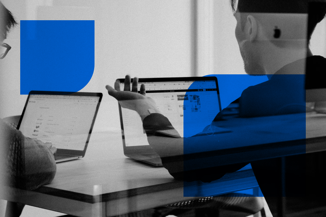 Colleagues collaborate on laptops with blue graphic overlay in workspace