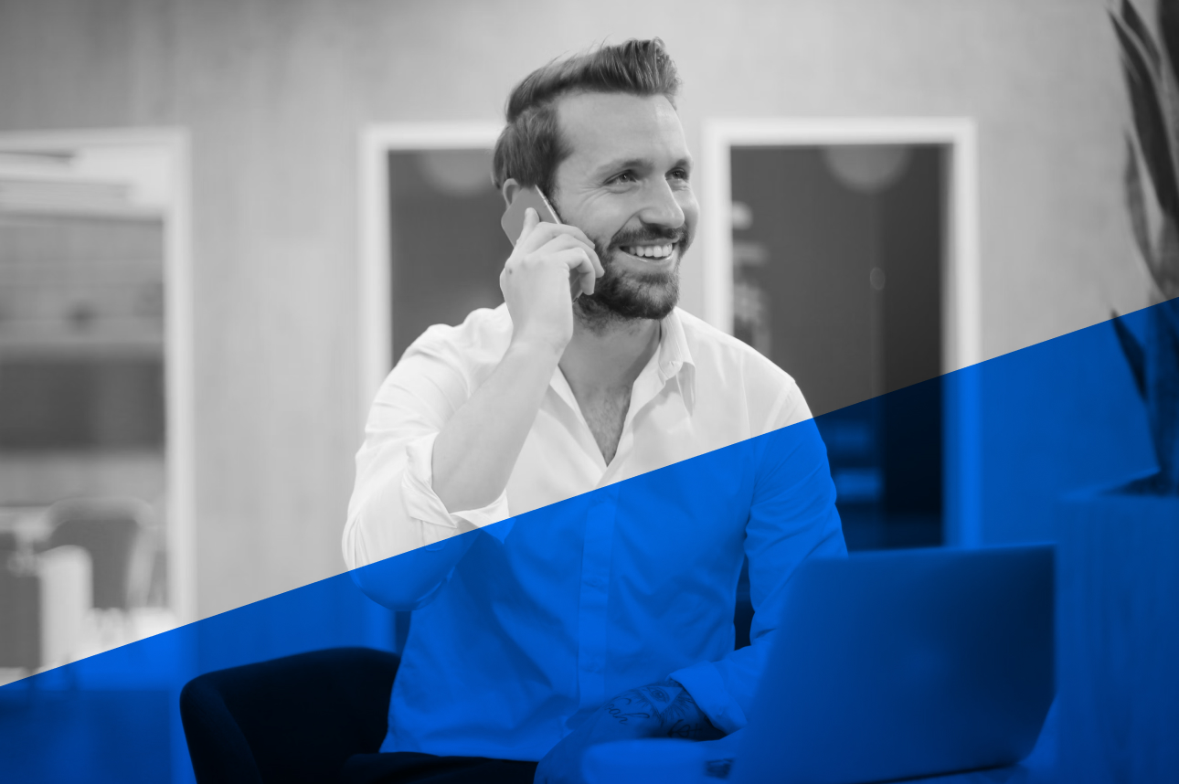 Smiling professional in white shirt talking on phone in office
