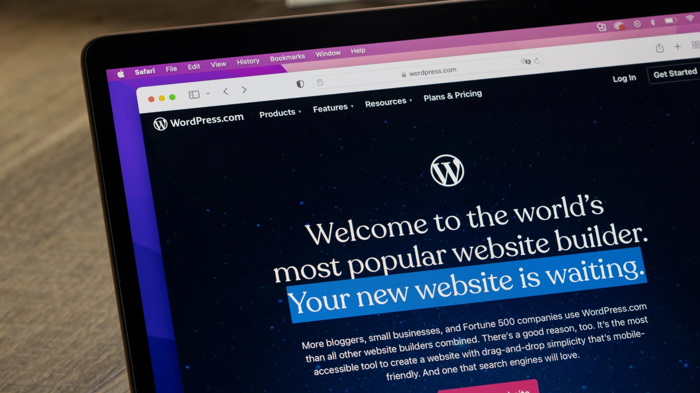 Laptop screen displaying the WordPress homepage and website builder features