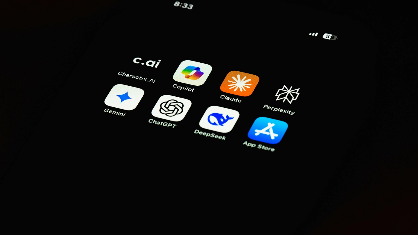 Tablet screen showing multiple AI app icons including Gemini, ChatGPT, Claude, Perplexity, DeepSeek, and Copilot on a black background