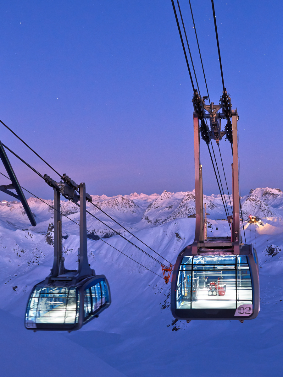 Seilbahnen in Arosa, umgeben von schneebedeckten Bergen.