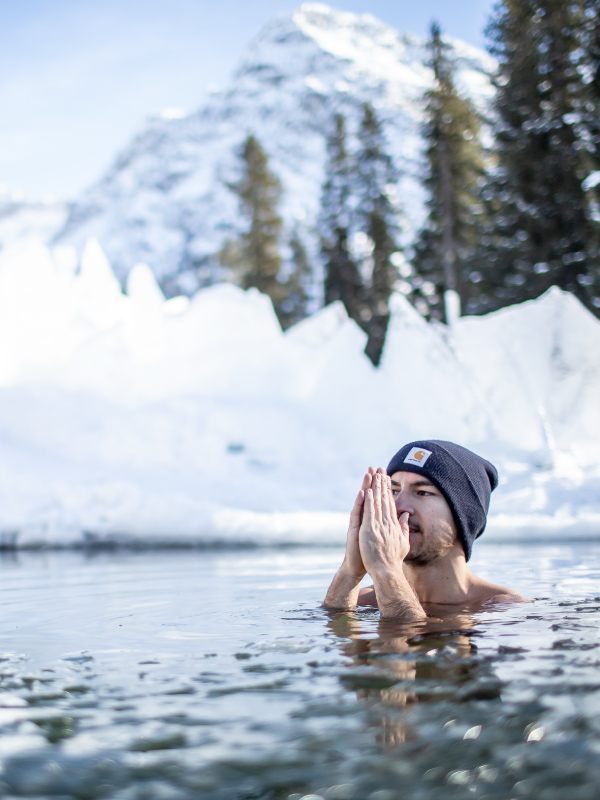 Mann im Ice Wasser, umgeben von Schnee in Arosa, Leadership Forum Erlebnis.