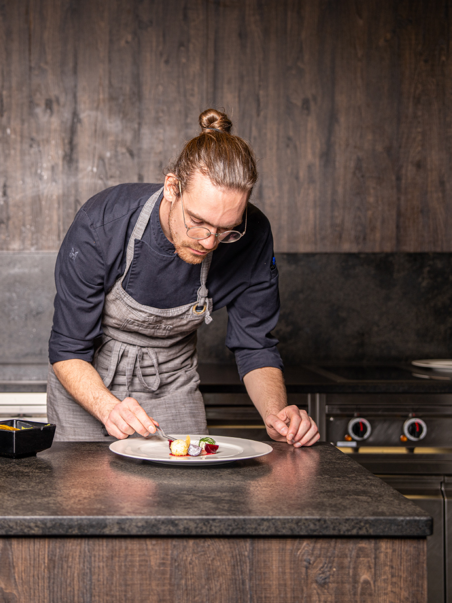 Ein Koch präsentiert ein Gericht in der Hotel Küche, in Arosa