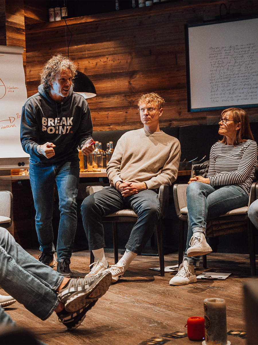 Speaker engaging participants during the Arosa Leadership Summit in a cozy workshop setting.