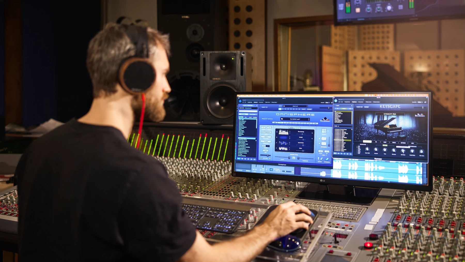 Tonter im Tonstudio bedient Mischpult mit Computerbildschirm für Musikbearbeitung.