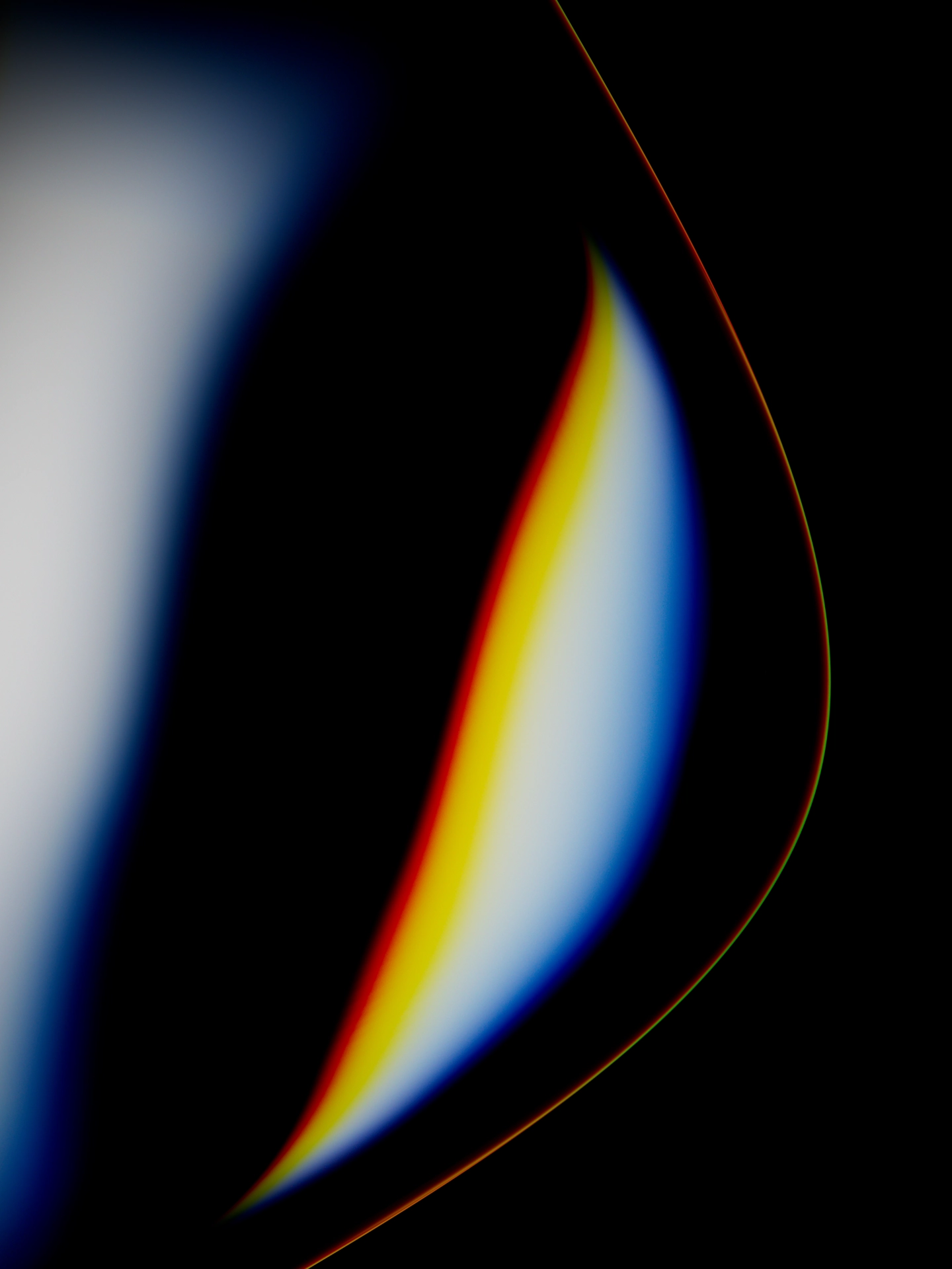 Close-up of a curved abstract shape with gradient colors including yellow, white, blue, and red on a black background.