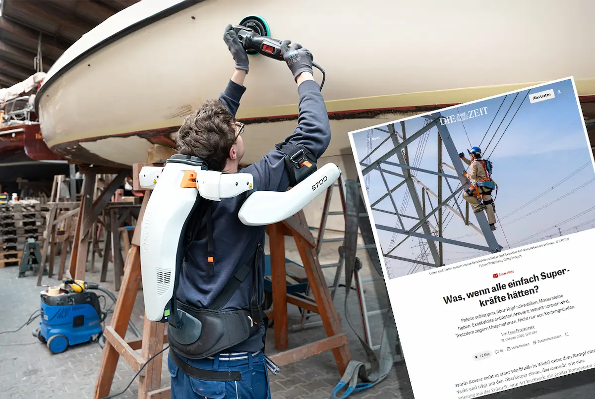 Worker using an exoskeleton to support overhead work during yacht maintenance in a shipyard.