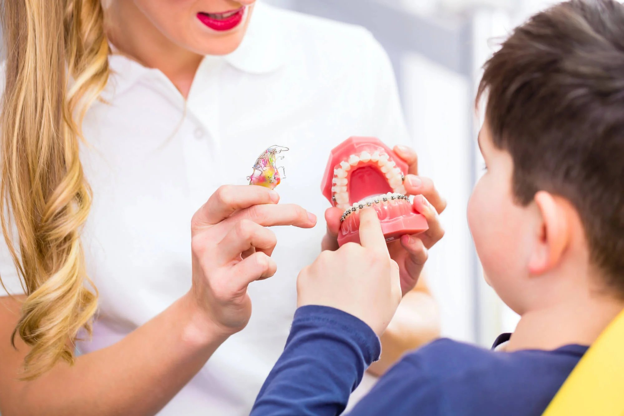 Family orthodontics in Quakertown explaining braces to young patient.