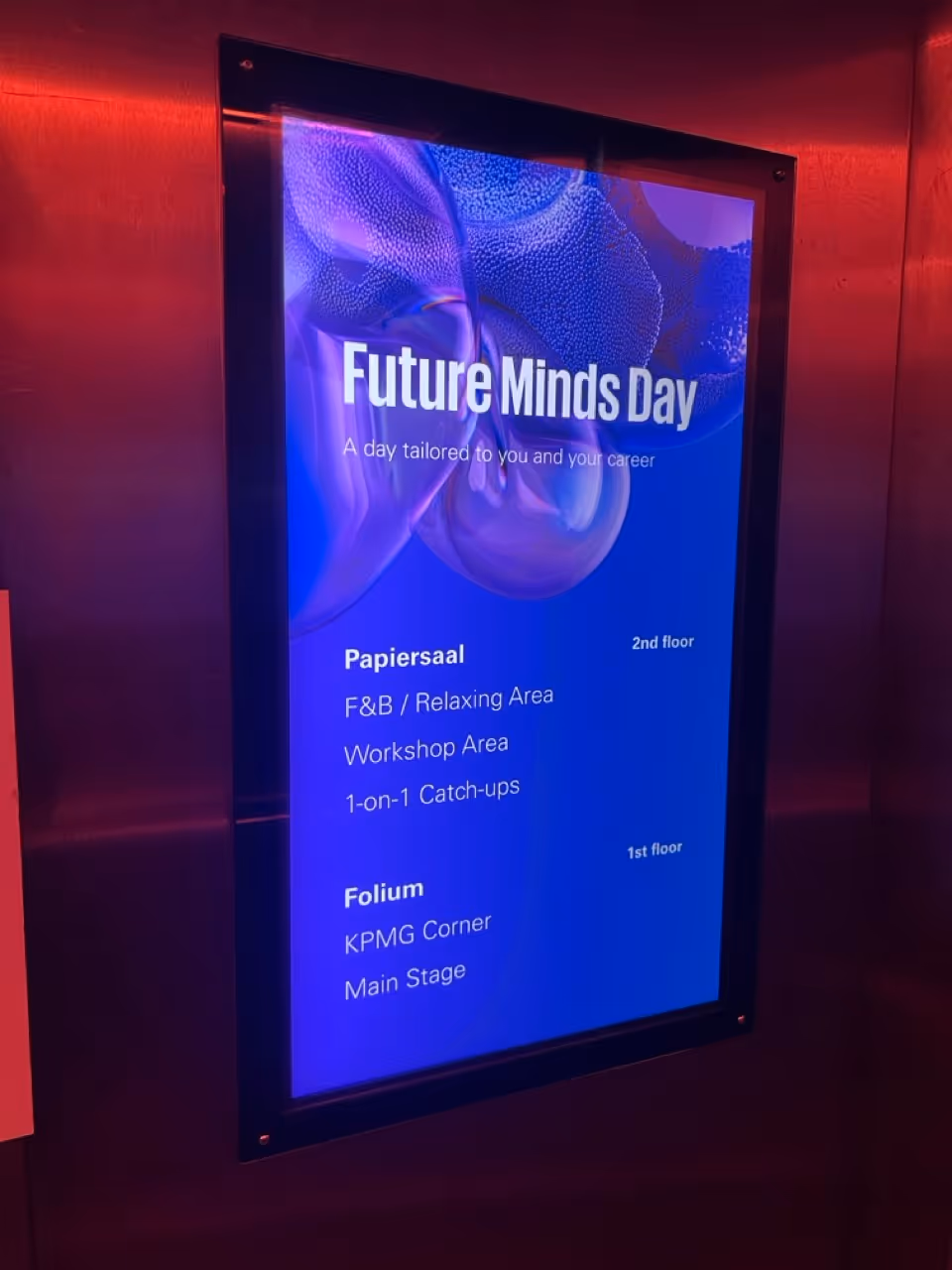 Digitales Infoschild zu Future Minds Day mit Veranstaltungsübersicht und Raumzuweisungen im Papiersaal (2. Stock) und Folium (1. Stock).