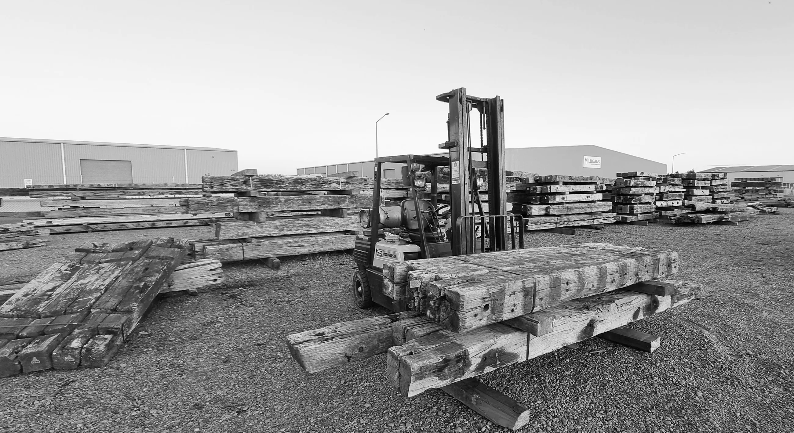 Forklift carrying recycled wharf & timber beams at the Renovo Timber Yard, Oamaru. 