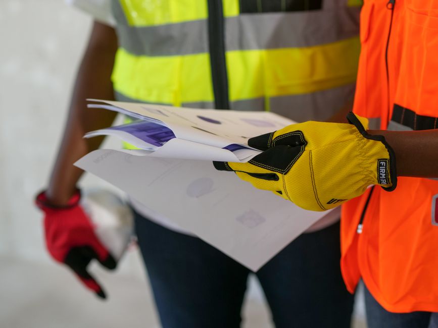 A worker carefully documenting workplace safety hazards on a clipboard