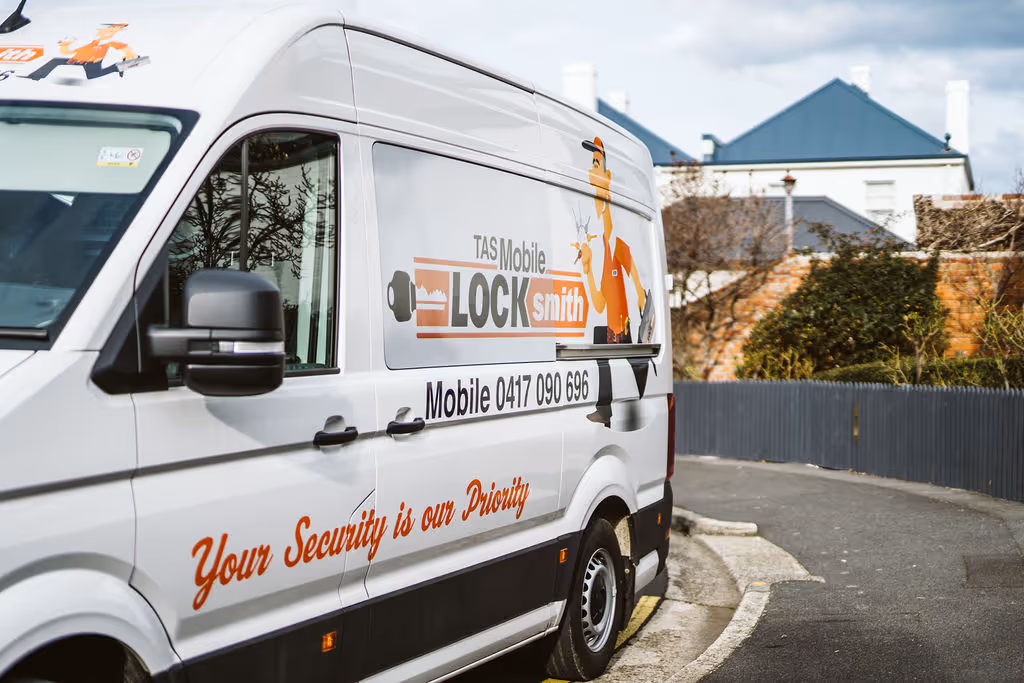White TAS Mobile Locksmith van parked on street with security slogan