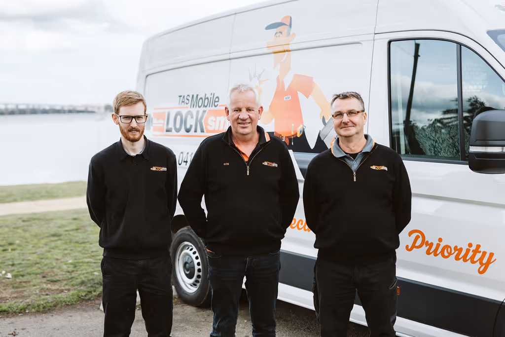 Three Lock SP employees standing in front of white company van