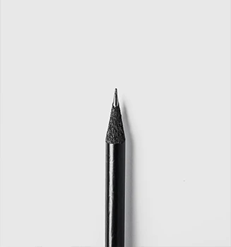 Close-up of black pencil on white surface.